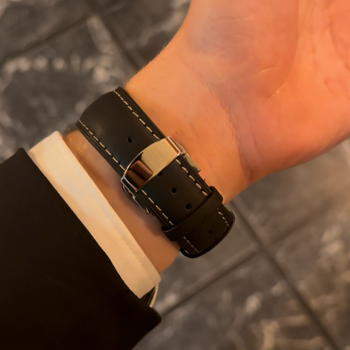 Leder Uhrenarmband Smoke Black in Schwarz am Handgelenk unter dem Anzugsärmel